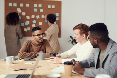Three men chatting in a meeting over coffee